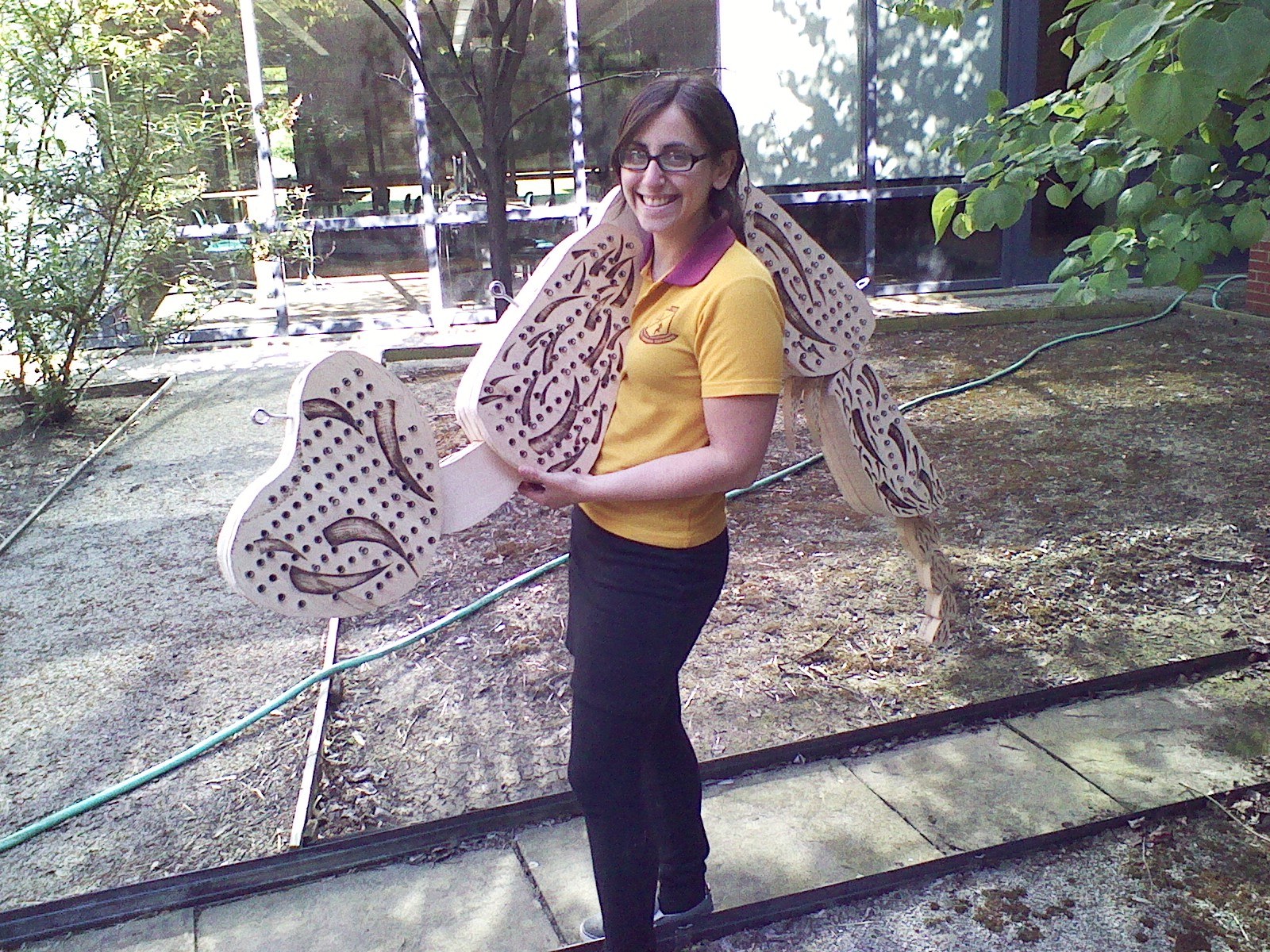 Karmi holding a bug-leg-shaped bee hotel